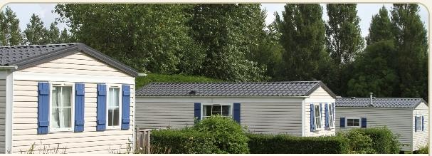 Mobile homes with blue shutters in a park setting